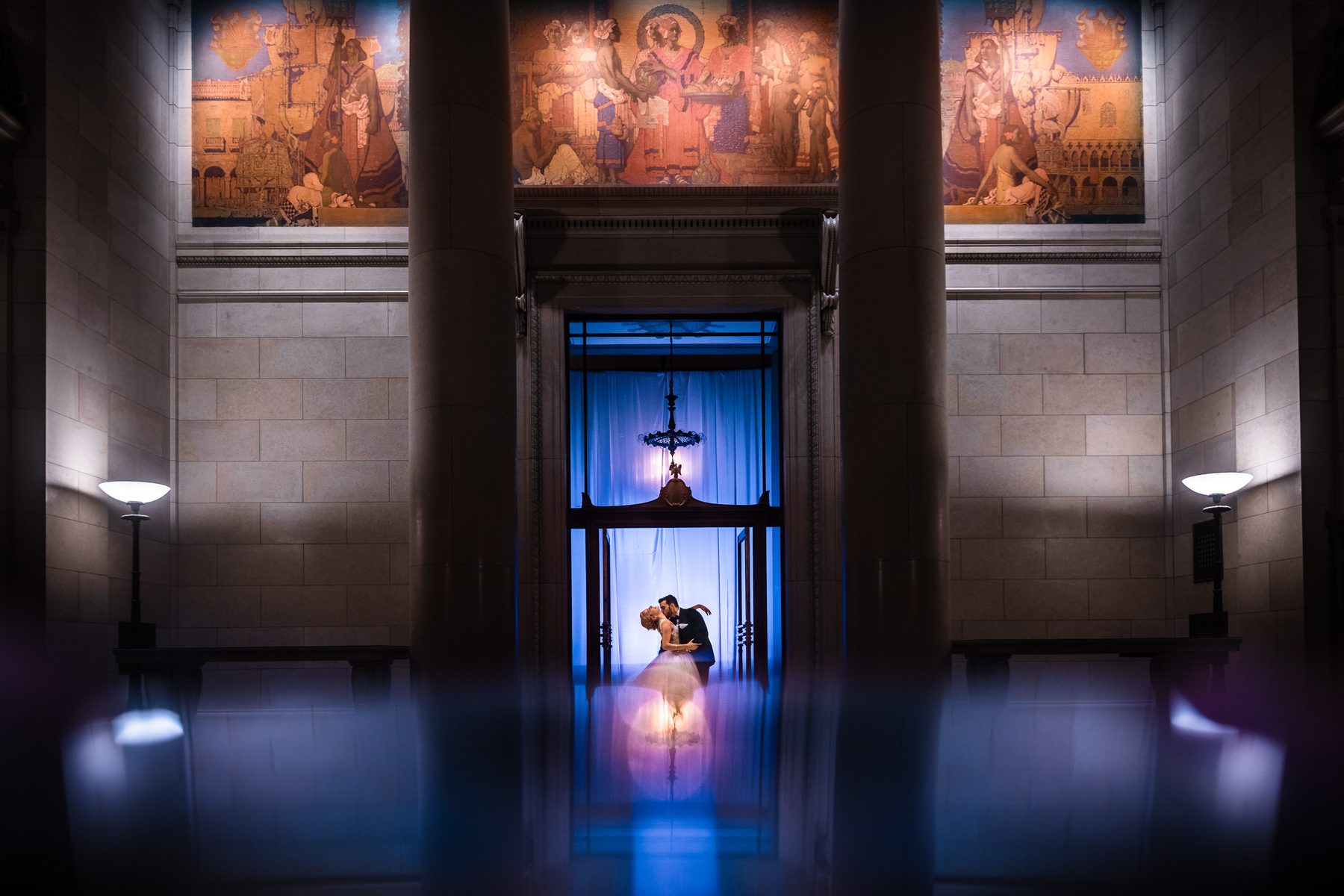 Bride and groom embracing between grand columns at the Bently Reserve in San Francisco