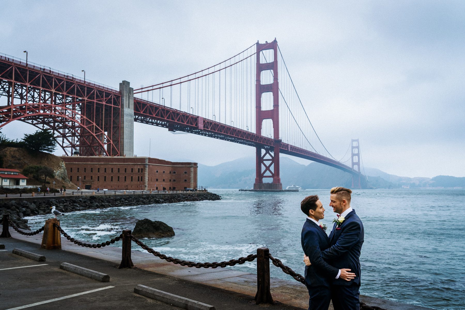 Grooms embracing at Fort Point after their San Francisco City Hall wedding