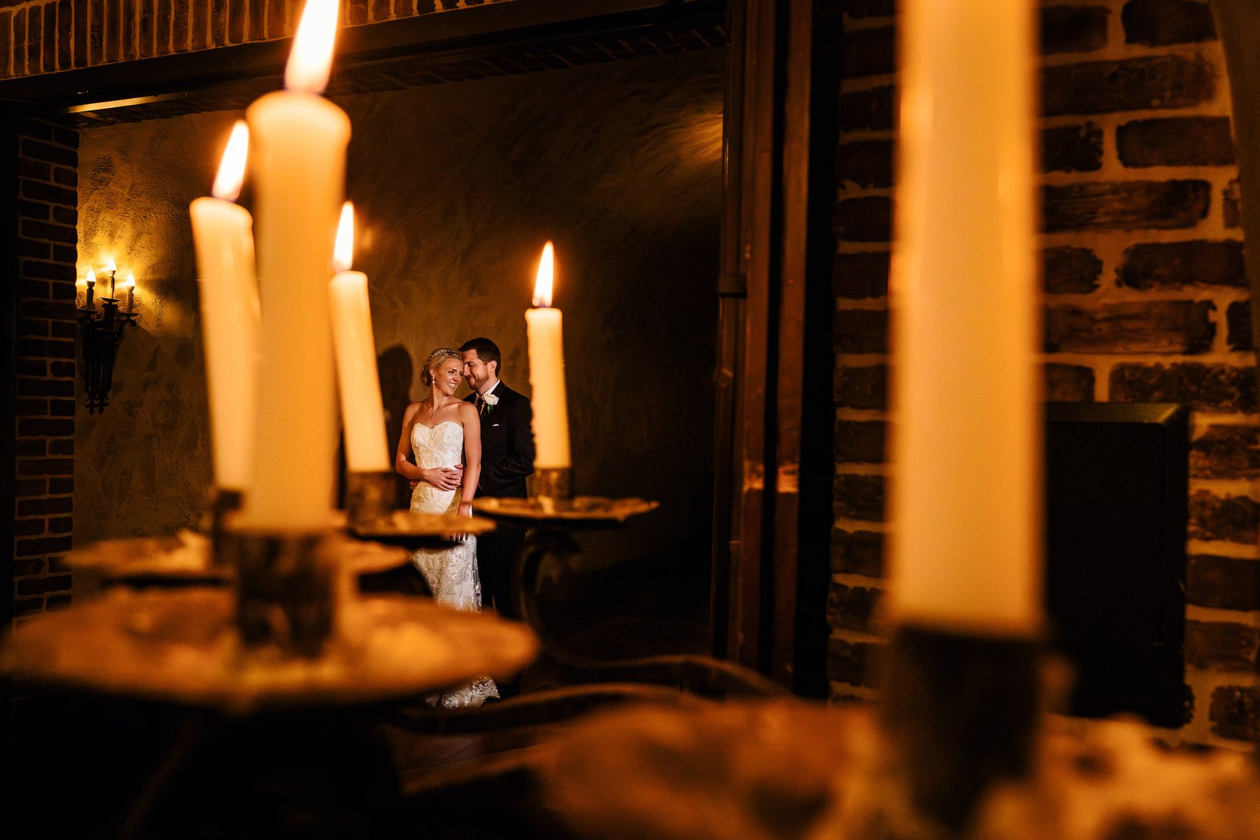 Bride and groom reflected in a candlelit window at The Meritage Resort in Napa Valley